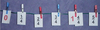 Fraction cards pegged to a rope to show intervals of quarters between zero and five quarters. Four quarters is also marked as 1.